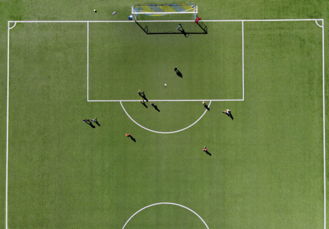 soccer-players-playing-a-match-on-a-green-sports-field-viewed-directly-from-overhead-from-a-drone-on-a-sunny-summer-day