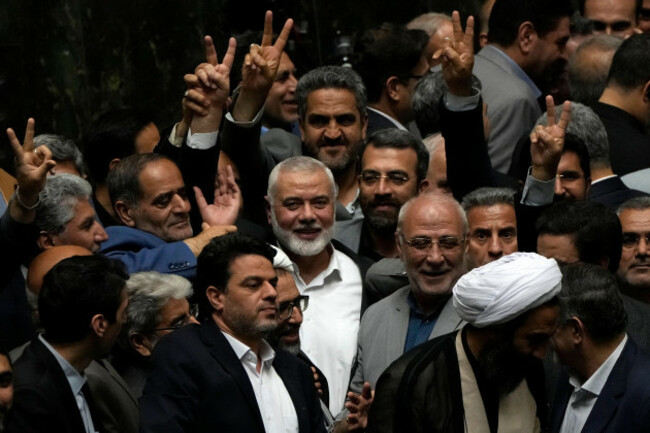 palestinian-hamas-chief-ismail-haniyeh-center-flashes-a-victory-sign-as-he-is-surrounded-by-a-group-of-iranian-lawmakers-after-the-conclusion-of-the-swearing-in-ceremony-of-newly-elected-iranian-pre