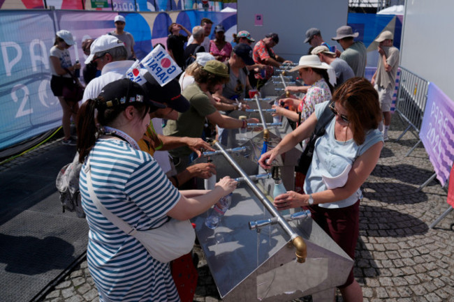 fans-fill-their-water-bottles-on-a-hot-afternoon-by-the-cycling-bmx-freestyle-venue-at-the-2024-summer-olympics-tuesday-july-30-2024-in-paris-france-ap-photofrank-franklin-ii