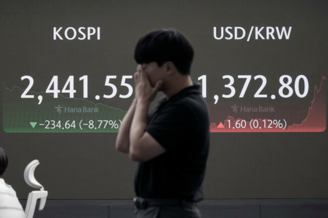 a-currency-trader-reacts-near-a-screen-showing-the-korea-composite-stock-price-index-kospi-left-and-the-foreign-exchange-rate-between-u-s-dollar-and-south-korean-won-at-the-foreign-exchange-deali