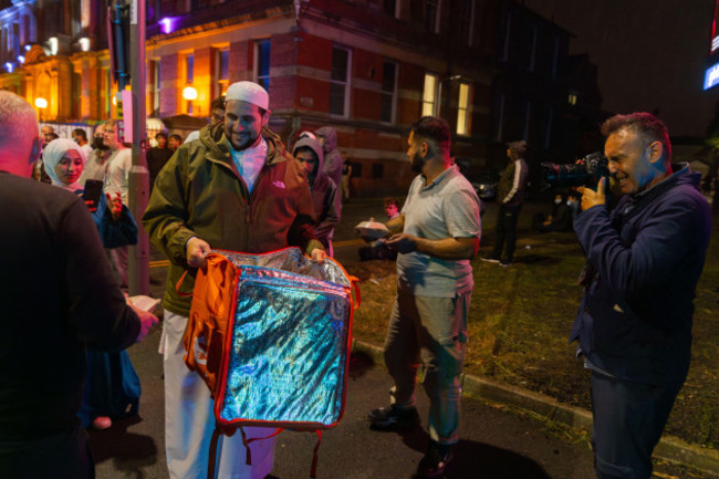 liverpool-uk-02-aug-2024-an-imam-from-the-abdullah-quiliam-mosque-crosses-the-road-with-food-to-give-to-the-opposing-side-protestors-identifying-as-right-wing-as-well-as-members-of-sutr-and-left