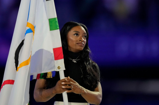 united-states-gymnast-simone-biles-holds-the-olympic-flag-during-the-2024-summer-olympics-closing-ceremony-at-the-stade-de-france-sunday-aug-11-2024-in-saint-denis-france-ap-photonatacha-pis