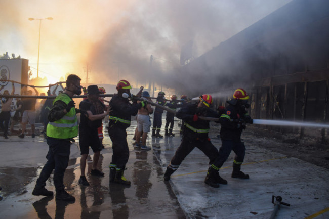 athens-greece-12-august-2024-firefighters-being-helped-by-volunteers-extinguish-the-fire-in-a-shop-in-the-vrilissia-suburb-of-the-greek-capital-a-wildfire-that-broke-out-in-varnavas-on-11-august