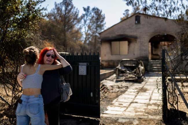 athen-greece-13th-aug-2024-a-woman-is-comforted-by-a-girl-in-front-of-her-burnt-down-house-which-was-destroyed-by-a-forest-fire-in-ano-patima-near-penteli-in-the-north-of-athens-just-a-few-kilom