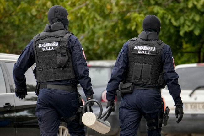 gendarmes-wearing-balaclavas-hold-a-battering-ram-used-to-break-down-a-door-outside-the-residence-of-internet-influencer-andrew-tate-during-an-early-morning-police-search-raid-on-the-outskirts-of-buc