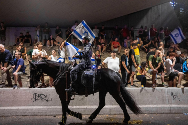 a-police-officer-on-a-horse-moves-past-a-protest-calling-for-a-deal-for-the-immediate-release-of-hostages-held-in-the-gaza-strip-by-hamas-in-tel-aviv-israel-sunday-sept-1-2024-ap-photoohad-zw