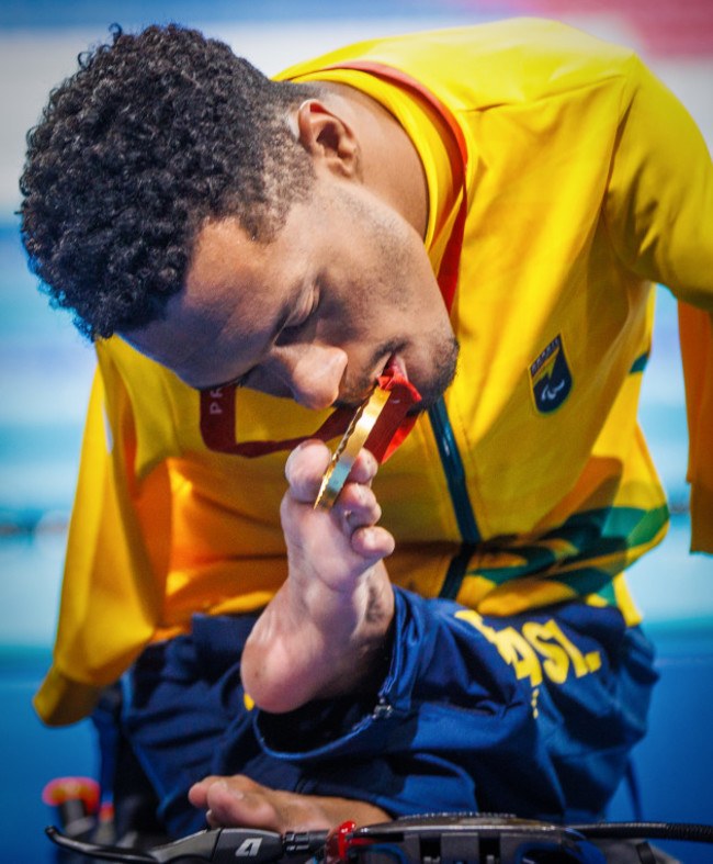 gabriel-geraldo-dos-santos-araujo-brings-his-gold-medal-to-his-mouth-to-pose-for-the-cameras-after-winning