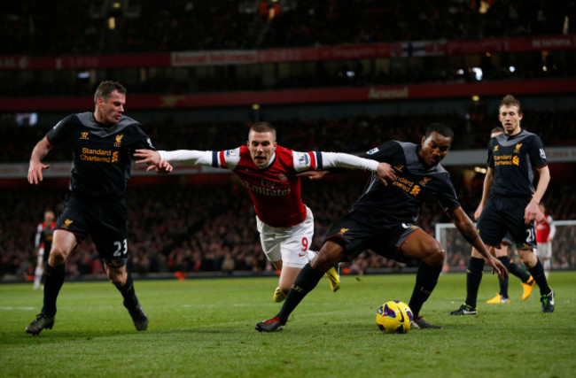 arsenals-lukas-podolski-center-competes-for-the-ball-with-liverpools-jamie-carragher-left-and-andre-wisdom-during-the-english-premier-league-soccer-match-between-arsenal-and-liverpool-at-the-emi