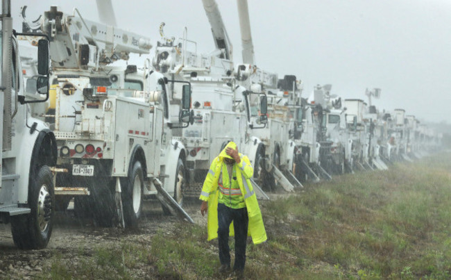 the-villages-florida-usa-26th-sep-2024-charles-starling-a-lineman-with-team-fishel-is-pelted-with-rain-as-he-walks-by-a-row-of-electrical-line-trucks-staged-in-a-field-in-the-villages-florida