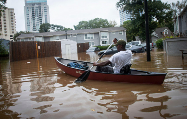 an-unidentified-man-paddles-a-canoe-to-rescue-residents-and-their-belongings-at-a-flooded-apartment-complex-after-hurricane-helene-passed-the-area-on-friday-sept-27-2024-in-atlanta-ap-photoron