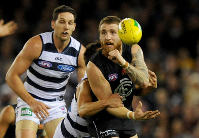 zach-tuohy-of-carlton-passes-the-ball-as-hes-tackled-by-mathew-stokes-of-geelong-during-the-round-12-afl-match-between-the-geelong-cats-and-carlton-blues-at-etihad-stadium-in-melbourne-friday-june