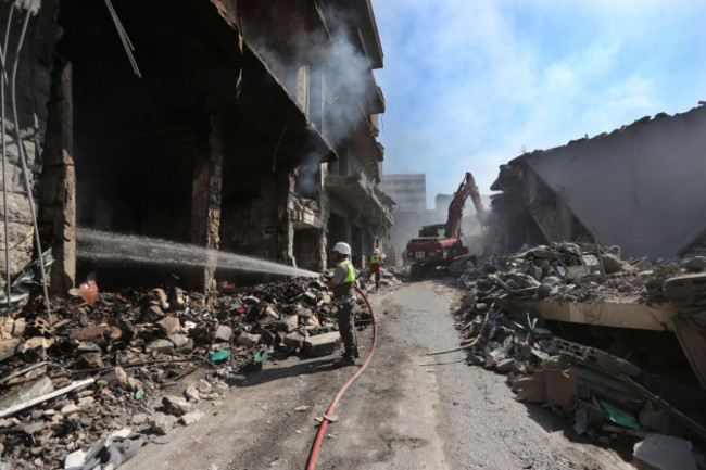 a-hezbollah-firefighter-hoses-down-on-burned-and-destroyed-shops-at-a-commercial-street-that-was-hit-saturday-night-by-israeli-airstrikes-in-nabatiyeh-town-south-lebanon-sunday-oct-13-2024-ap