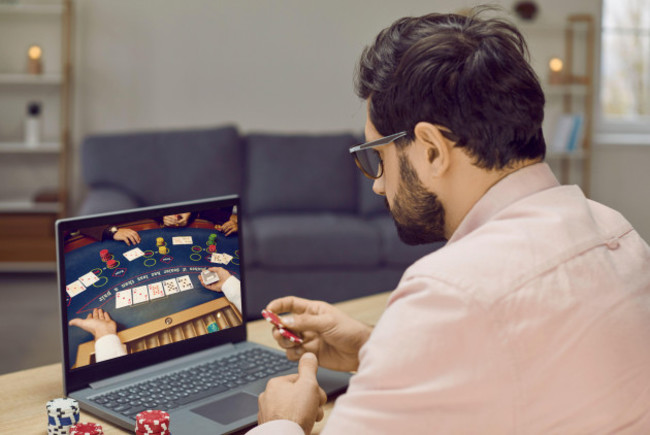 young-gambling-man-takes-part-in-online-poker-tournament-while-relaxing-at-home