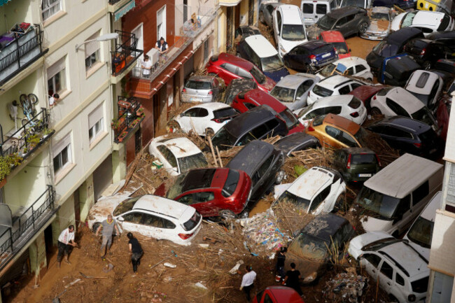 residents-clean-the-street-next-to-cars-piled-up-after-being-swept-away-by-floods-in-valencia-spain-wednesday-oct-30-2024-ap-photoalberto-saiz