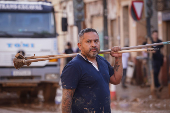 a-man-carries-a-mop-and-a-broom-during-mud-cleanup-in-a-flooded-area-in-the-la-torre-neighbourhood-of-valencia-spain-friday-nov-1-2024-ap-photoalberto-saiz