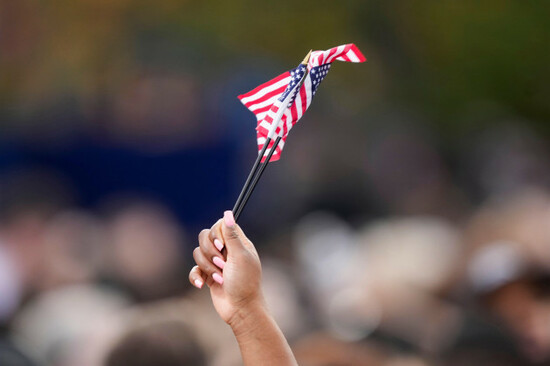 a-supporter-waves-american-flags-while-waiting-for-vice-president-kamala-harris-to-arrive-to-deliver-a-concession-speech-for-the-2024-presidential-election-on-the-campus-of-howard-university-in-washin