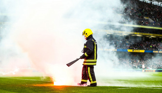 a-member-of-the-civil-defence-removes-a-flare-form-the-pitch-after-andrew-quinn-scores