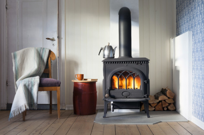 interiorwithwoodheatingstovechairwithplaidandfirewood