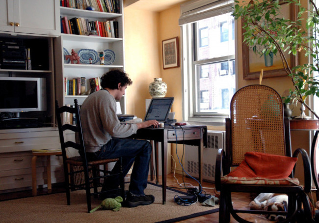 young-man-in-20s-working-on-computer-checking-post-and-job-hunting-in-parents-apartment