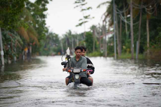 residents-ride-on-a-self-modified-motorcycle-through-a-road-covered-by-flood-water-in-tumpat-outskirts-of-kota-bahru-malaysia-tuesday-dec-3-2024-ap-photovincent-thian