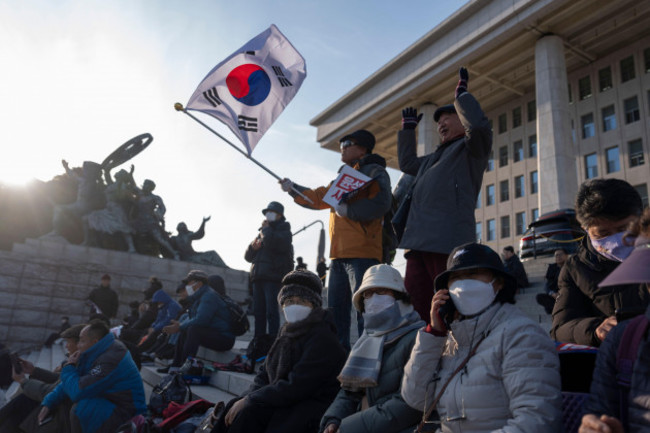 a-protester-waves-a-south-korean-flag-as-he-joins-others-gathering-outside-the-national-assembly-in-seoul-south-korea-wednesday-dec-4-2024-ap-photong-han-guan