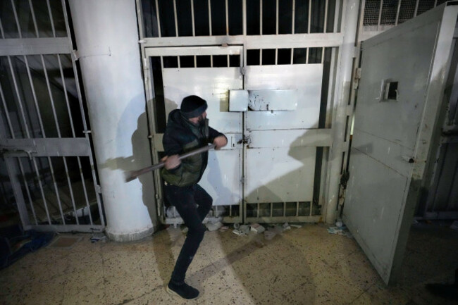 a-man-breaks-the-lock-of-a-cell-in-the-infamous-saydnaya-military-prison-just-north-of-damascus-syria-monday-dec-9-2024-crowds-are-gathering-to-enter-the-prison-known-as-the-human-slaughterho