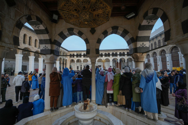 people-watch-and-take-photos-with-their-cell-phones-as-opposition-supporters-celebrate-in-the-courtyard-of-the-umayyad-mosque-in-the-old-walled-city-of-damascus-syria-on-tuesday-dec-10-2024-ap