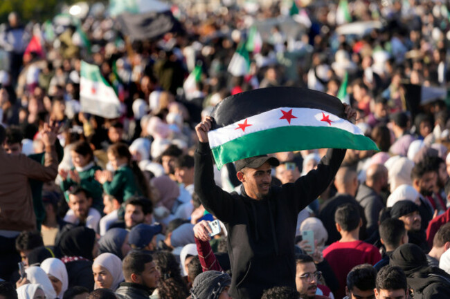 a-syrian-man-waves-the-revolutionary-syrian-flag-during-a-celebratory-demonstration-following-the-first-friday-prayers-since-bashar-assads-ouster-in-damascus-central-square-syria-friday-dec-1