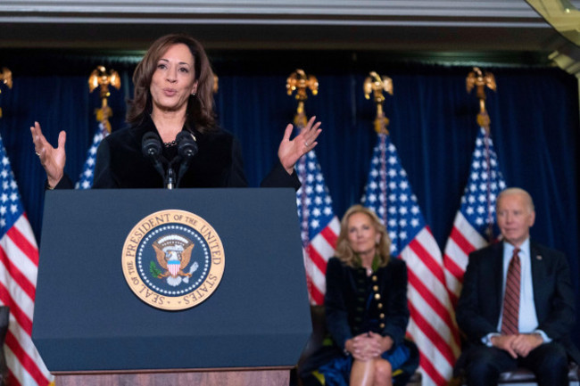 vice-president-kamala-harris-delivers-her-remarks-as-first-lady-jill-biden-back-center-and-president-joe-biden-back-right-look-on-at-the-democratic-national-committees-holiday-reception-at-willar