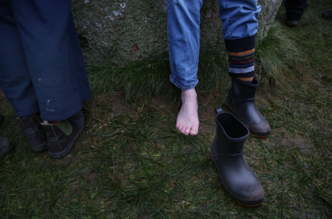 salisbury-england-uk-21st-dec-2024-a-visitor-takes-his-shoes-and-socks-off-to-experience-grounding-by-the-stones-during-the-winter-solstice-celebrations-the-winter-solstice-2024-marks-both-the-s