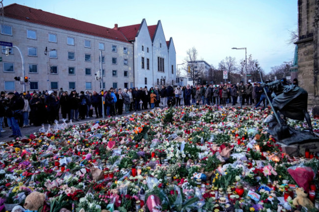 people-lay-flowers-and-lit-candles-in-front-of-the-johannis-church-close-to-the-christmas-market-where-a-car-drove-into-a-crowd-on-friday-evening-in-magdeburg-germany-sunday-dec-22-2024-ap-ph