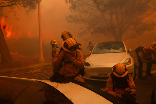 firefighters-try-to-protect-themselves-from-flying-embers-from-the-palisades-fire-in-the-pacific-palisades-neighborhood-of-los-angeles-tuesday-jan-7-2025-ap-photoetienne-laurent