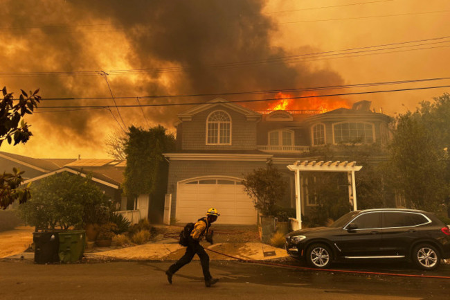 a-residence-burns-as-a-firefighter-battles-the-palisades-fire-in-the-pacific-palisades-neighborhood-of-los-angeles-tuesday-jan-7-2025-ap-photoeugene-garcia