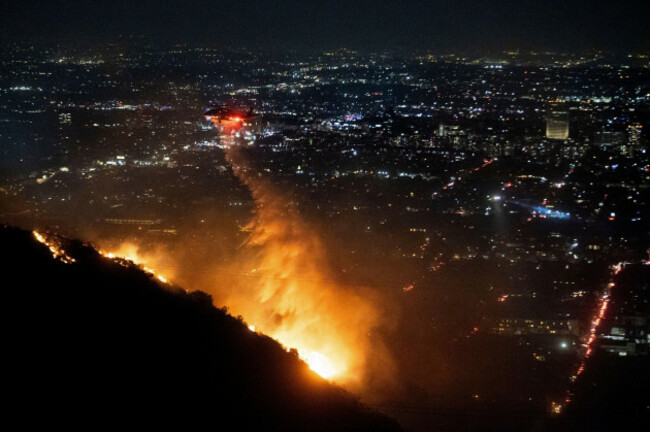 water-is-dropped-by-helicopter-on-the-burning-sunset-fire-in-the-hollywood-hills-section-of-los-angeles-wednesday-jan-8-2025-ap-photoethan-swope