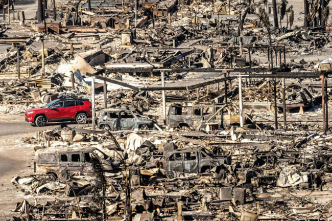 a-car-drives-past-homes-and-vehicles-destroyed-by-the-palisades-fire-at-the-pacific-palisades-bowl-mobile-estates-on-sunday-jan-12-2025-in-los-angeles-ap-photonoah-berger