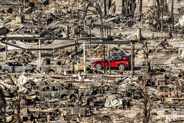 a-car-drives-past-homes-and-vehicles-destroyed-by-the-palisades-fire-at-the-pacific-palisades-bowl-mobile-estates-on-sunday-jan-12-2025-in-los-angeles-ap-photonoah-berger