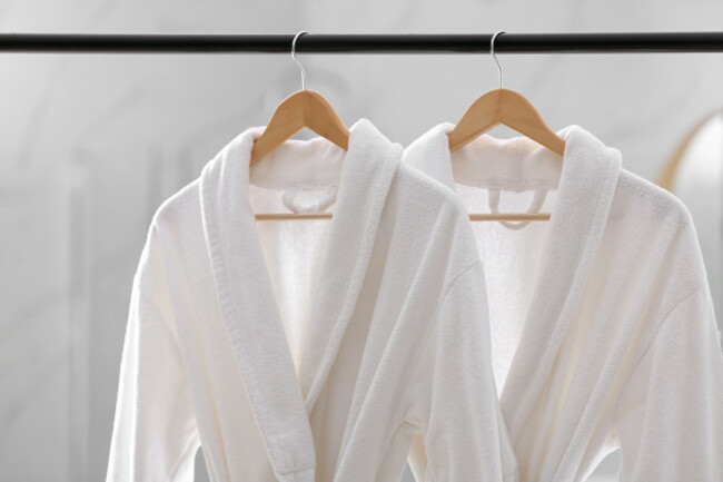 freshwhitebathrobeshangingonrackindoors