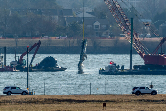 a-piece-of-wreckage-is-lifted-from-the-water-onto-a-salvage-vessel-near-the-site-in-the-potomac-river-of-a-mid-air-collision-between-an-american-airlines-jet-and-a-black-hawk-helicopter-at-ronald-rea
