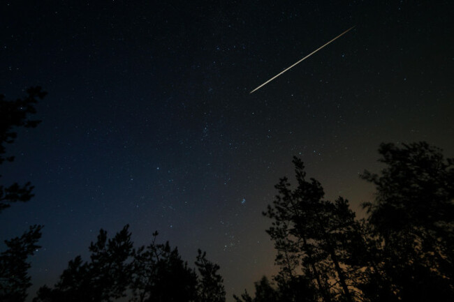 night-scene-with-starry-sky-and-meteorite-trail-over-forest-long-exposure-shoot