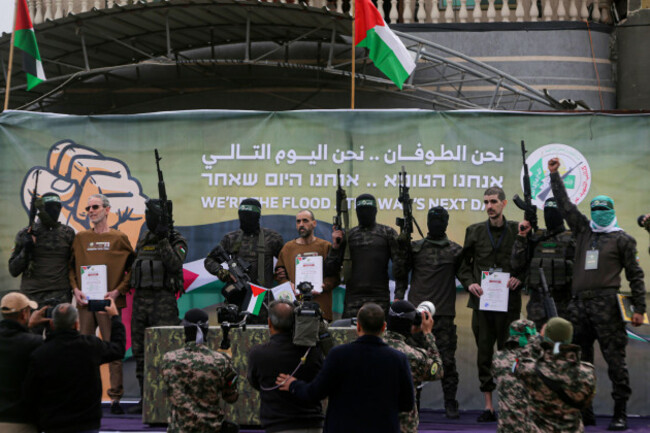 israeli-captives-from-left-to-right-ohad-ben-ami-eli-sharabi-and-or-levy-who-have-been-held-hostage-by-hamas-in-gaza-since-oct-7-2023-are-escorted-by-hamas-fighters-before-being-handed-over-to