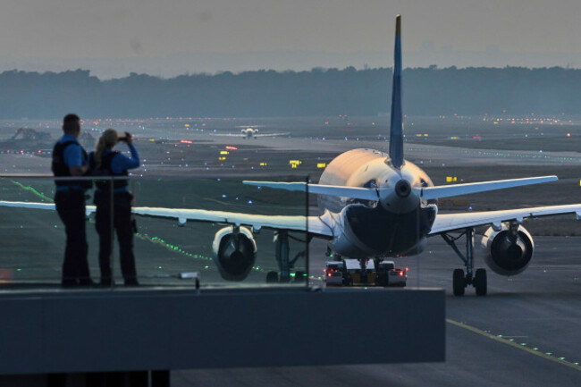 police-officers-watch-aircrafts-take-their-parking-positions-at-the-airport-in-frankfurt-germany-sunday-march-9-2025-the-evening-before-a-warning-strike-of-all-major-german-airports-ap-photomi
