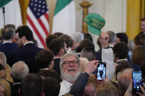 a-guest-holds-up-a-green-maga-hat-during-the-st-patricks-day-reception-and-shamrock-ceremony-in-the-the-east-room-of-the-white-house-in-washington-dc-as-part-of-taoiseach-micheal-martins-week-lo