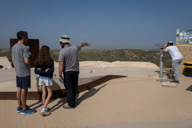 sderot-israel-18th-mar-2025-an-israeli-looks-through-binoculars-looking-into-the-northern-gaza-strip-r-as-other-visitors-get-an-explanation-of-thegaza-strip-in-background-as-they-view-the-dama