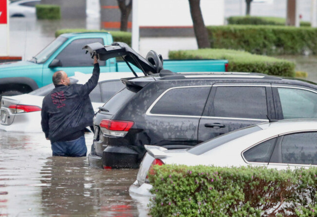 a-man-closes-the-trunk-of-his-vehicle-after-it-was-caught-in-a-flood-in-near-the-mcallen-convention-center-during-a-downpour-on-thursday-march-27-2025-in-mcallen-texas-joel-martinez-the-monito