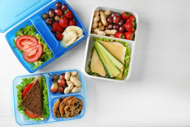 lunchboxes-with-dinner-on-white-wooden-background