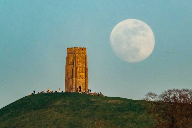 glastonbury-somerset-uk-11th-april-2025-uk-weather-the-almost-full-pink-moon-rises-up-from-behind-st-michaels-tower-on-glastonbury-tor-in-somerset-as-a-crowd-of-people-gather-on-top-of-the-hi