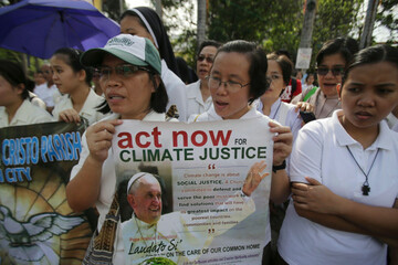 filipinos-hold-a-poster-with-a-picture-of-pope-francis-during-the-climate-solidarity-prayer-march-in-manila-philippines-sunday-nov-29-2015-the-group-urges-decisive-actions-from-world-leaders-who