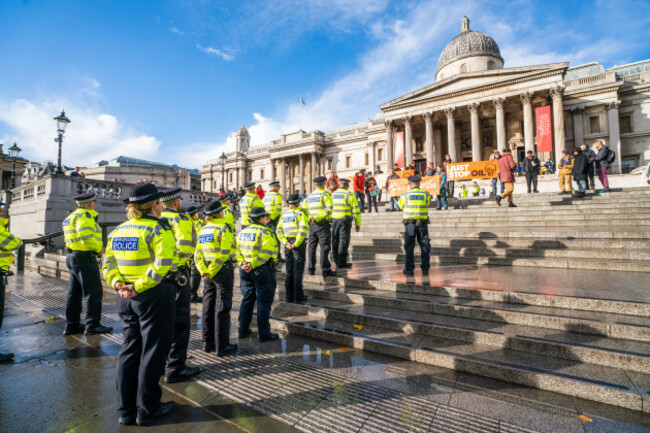 london-uk-1-november-2022-police-officers-stand-watch-as-just-stop-oil-protesters-display-banners-in-trafalgar-square-as-they-continue-their-daily-protest-for-the-32nd-consecutive-day-to-force