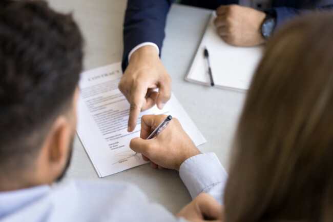 legalexpertpointingatspaceforsignatureinpaperdocument