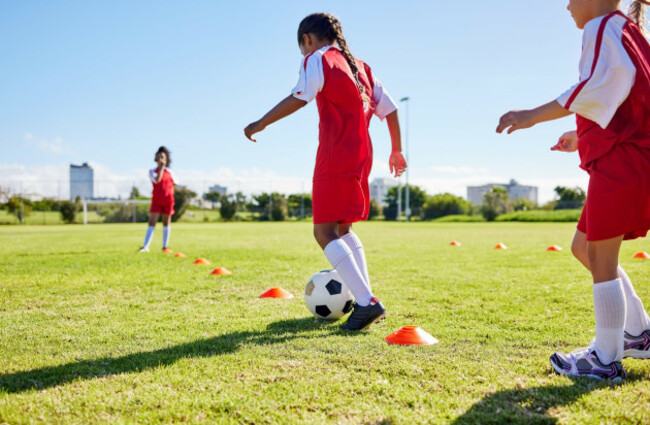 football-training-or-sports-and-a-girl-team-playing-with-a-ball-together-on-a-field-for-practice-fitness-soccer-and-grass-with-kids-running-or